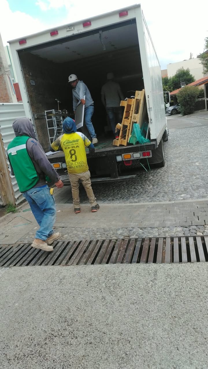 Personal de Transportes Valdez cargando muebles a un camión de caja seca