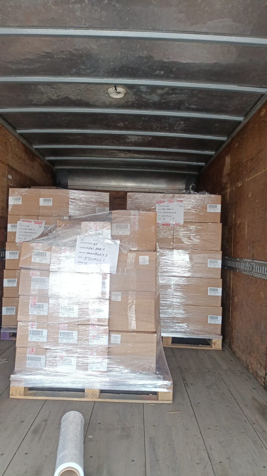 Tarimas con cajas emplayadas acomodadas dentro de un camión de caja seca